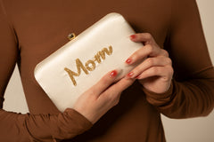 White Mom Clutch Bag for Mother's Day. Mom is written in 4-5 line gold beadwork.